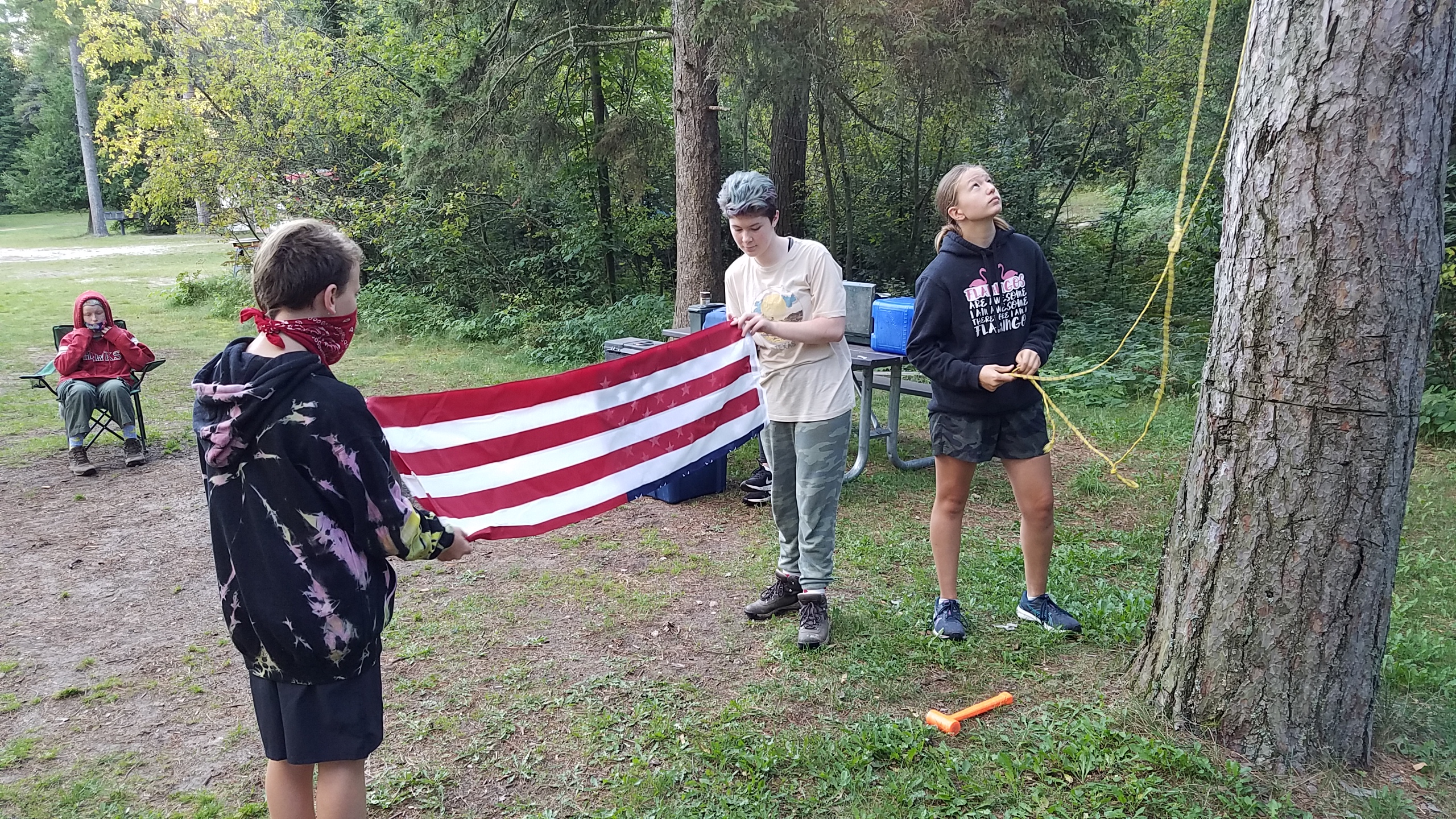 2 Scouts folding a flag one preparing the lines.