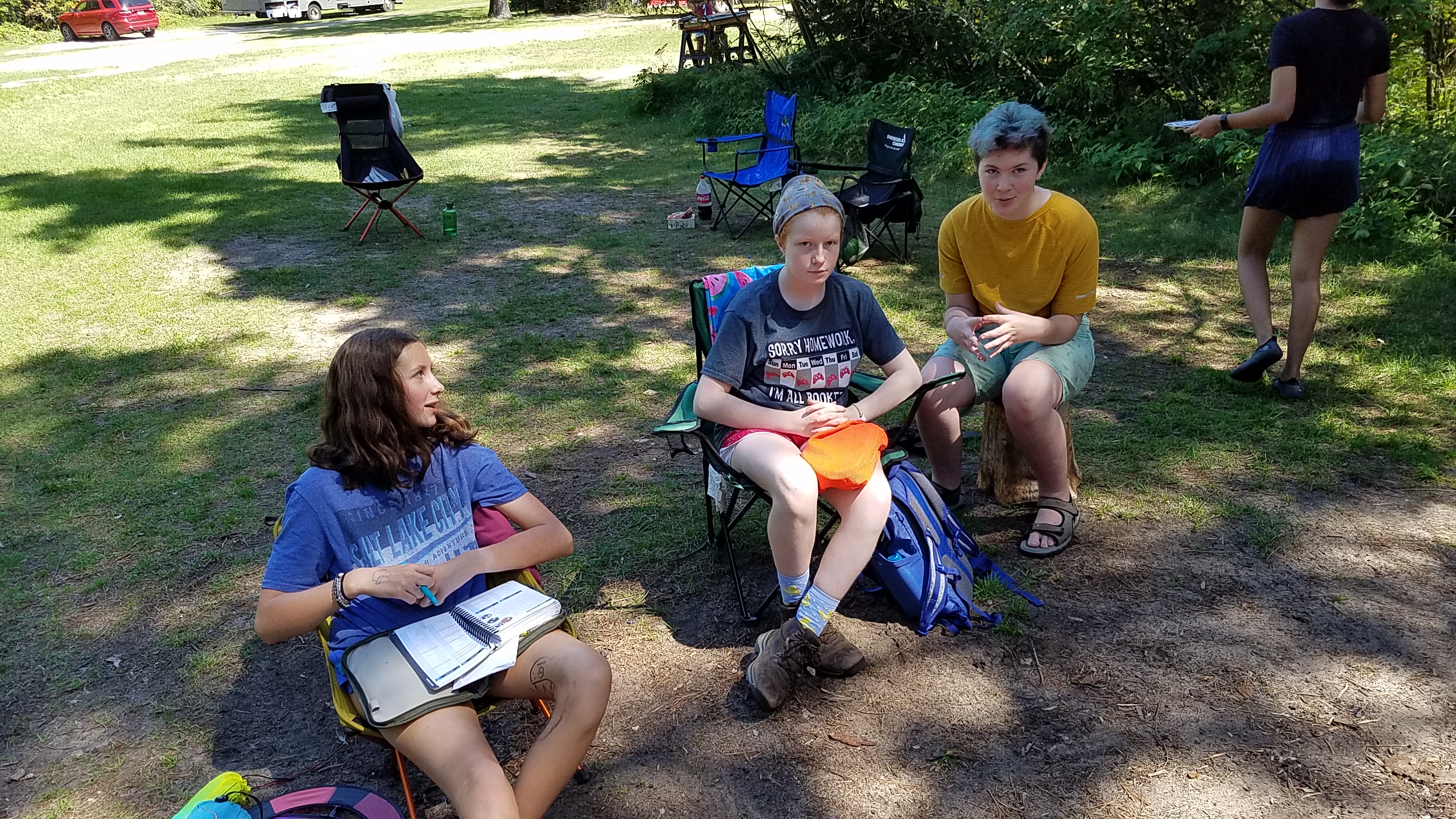3 scouts sitting at camp