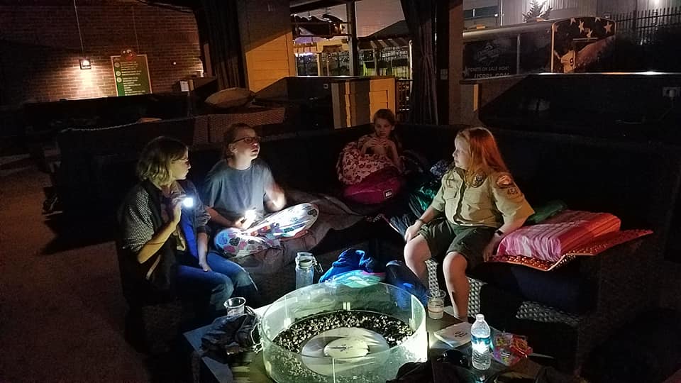 Scouts sitting in a circle with flashlights