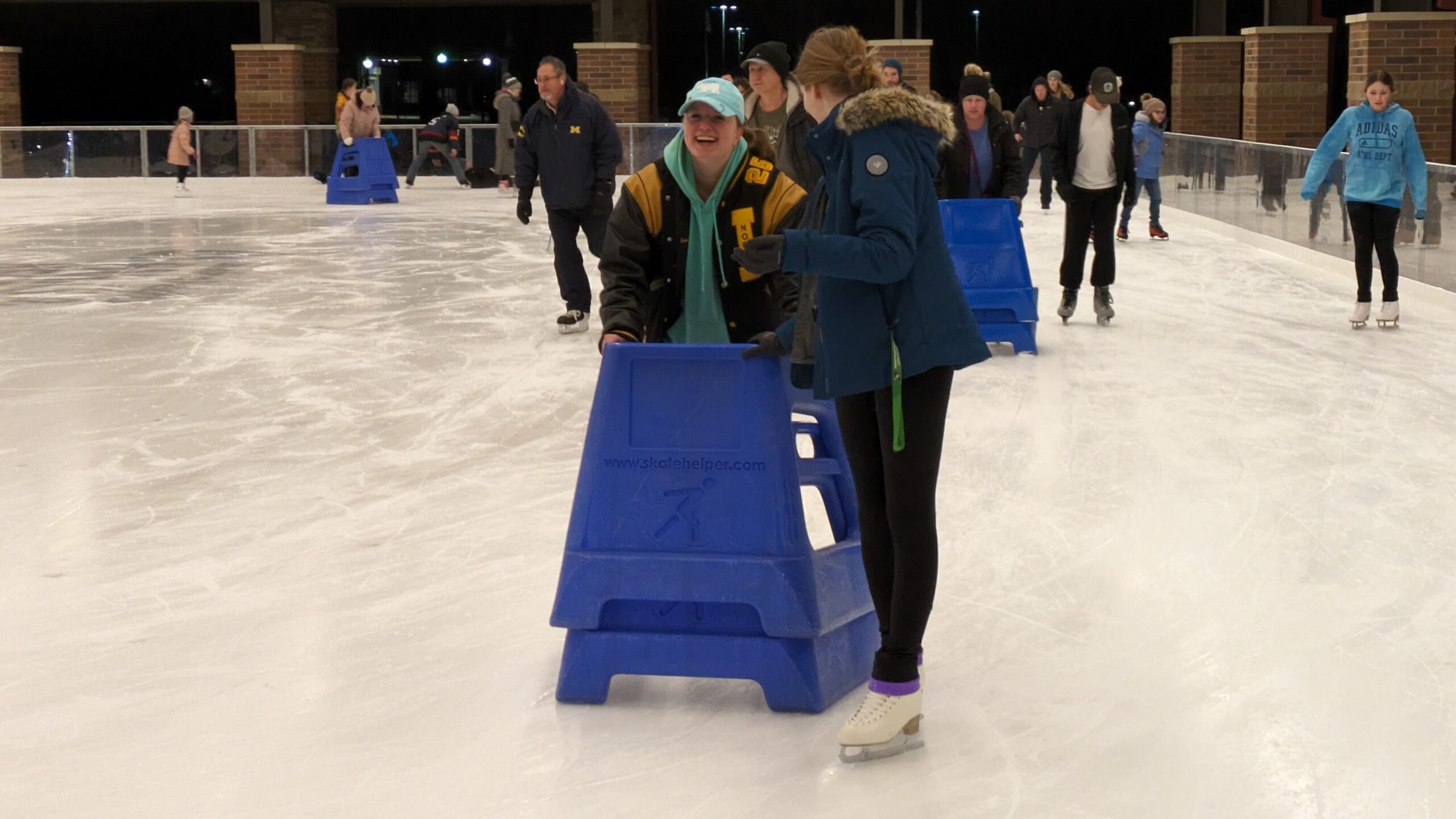 Scout helps another troop member learn to skate